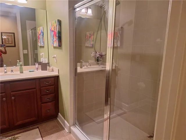 Bathroom featuring vanity, a shower stall, and tile patterned flooring