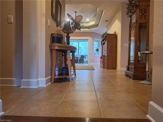 Hall featuring a textured wall and tile patterned floors