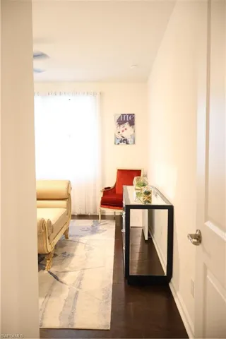 Hallway featuring baseboards and dark wood-style floors