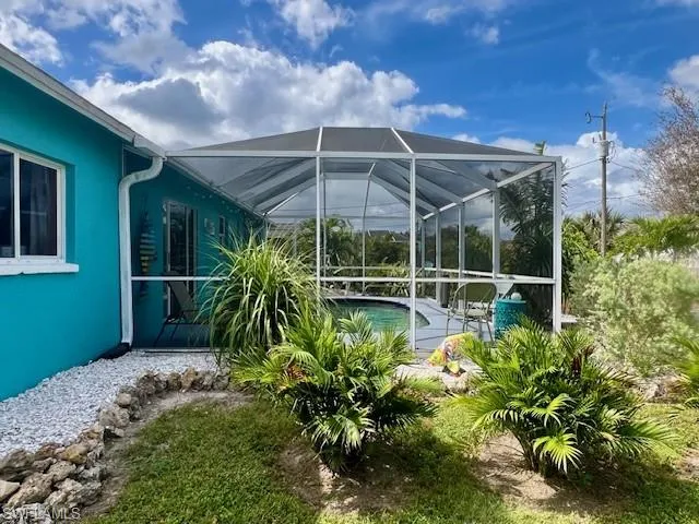 The side landscaping of the home toward the pool cage.