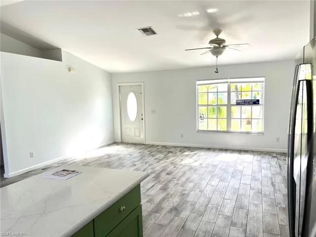Entrance foyer with light hardwood / wood-style floors and ceiling fan