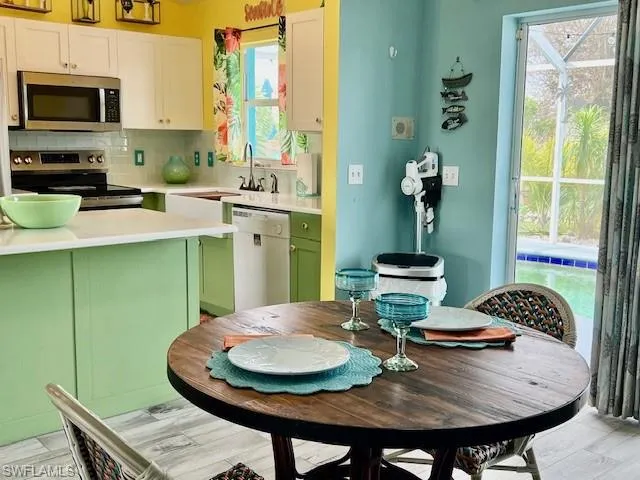 Kitchen with appliances with stainless steel finishes, tile flooring, overlooking the pool and a healthy amount of sunlight