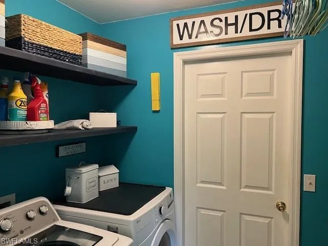 Washroom featuring independent washer and dryer, floating shelves