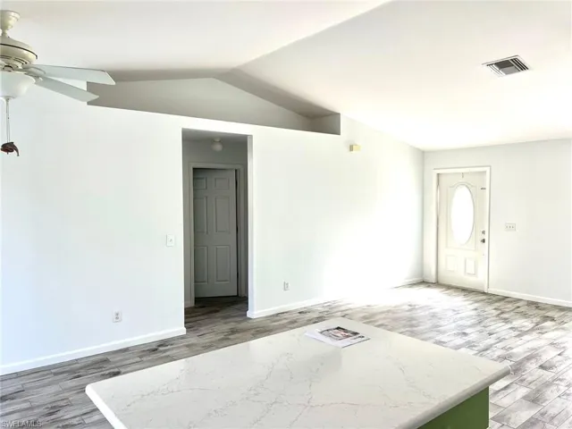 Spare room featuring hardwood / wood-style floors, ceiling fan, and lofted ceiling