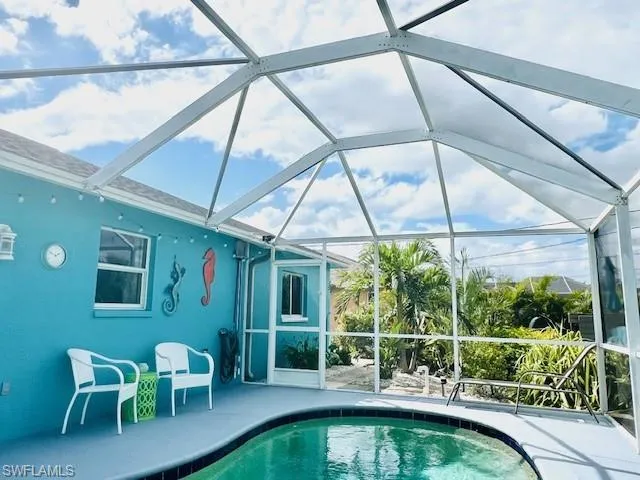 View of swimming pool with a patio area and a lanai