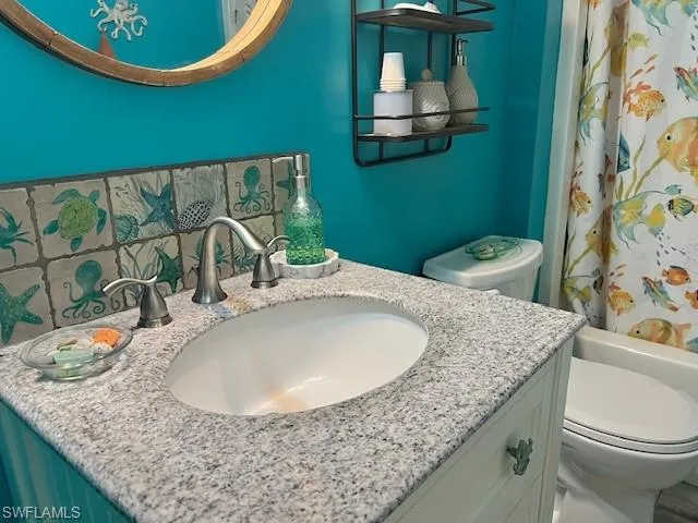 Second full bathroom featuring vanity, toilet, and shower / tub combo with curtain.  New vanity, tile flooring