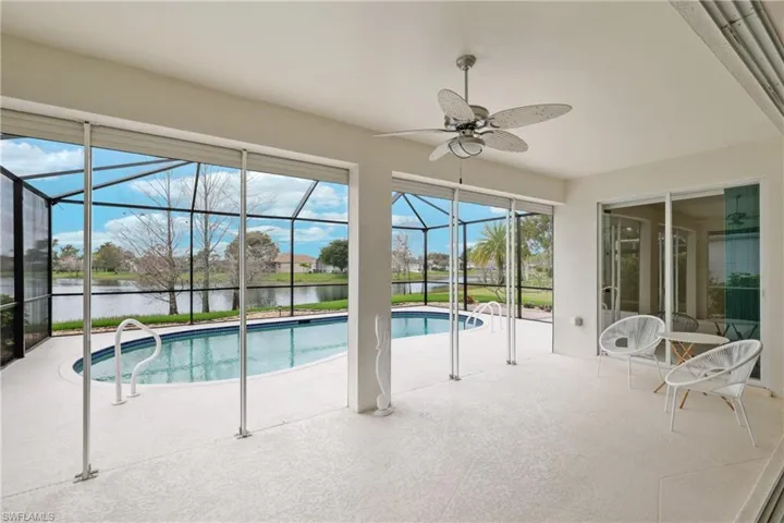 View of pool featuring a covered lanai, ceiling fan, a lake view and screened enclosure