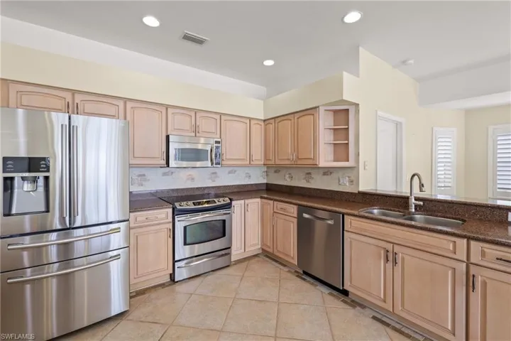 Kitchen with stainless steel appliances, tasteful backsplash, sink, and wooden cabinets