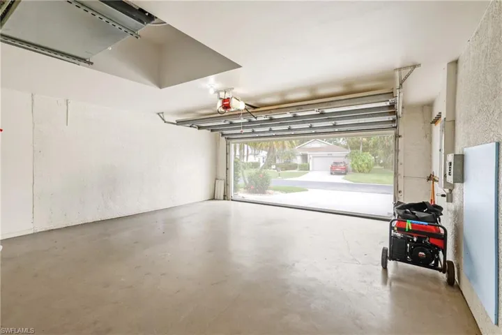Garage featuring a generator and skeeter beater screen door.