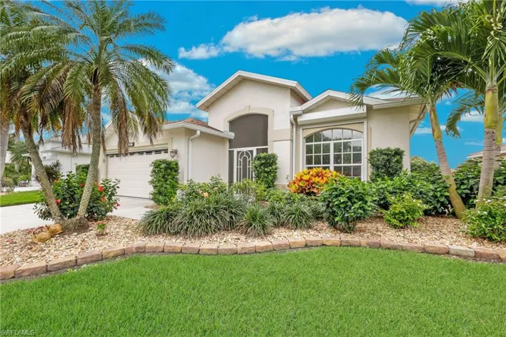 Ranch-style home with a lush front yard and a garage