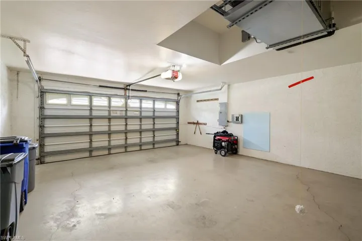 Garage featuring electric panel and a garage door opener
