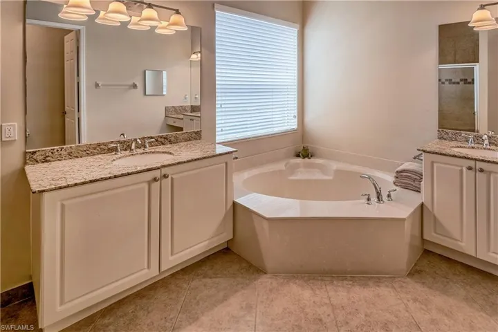 Bathroom with plenty of natural light, a bathing tub, and tile patterned flooring