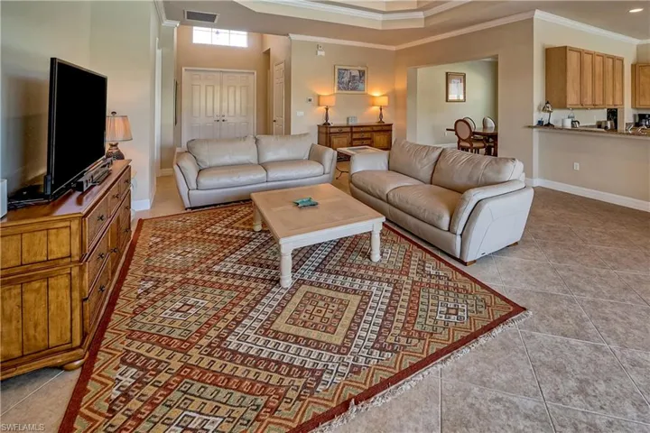 Living room with crown molding and tile patterned flooring