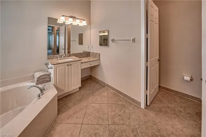 Bathroom featuring vanity, tile patterned floors, and a bathtub