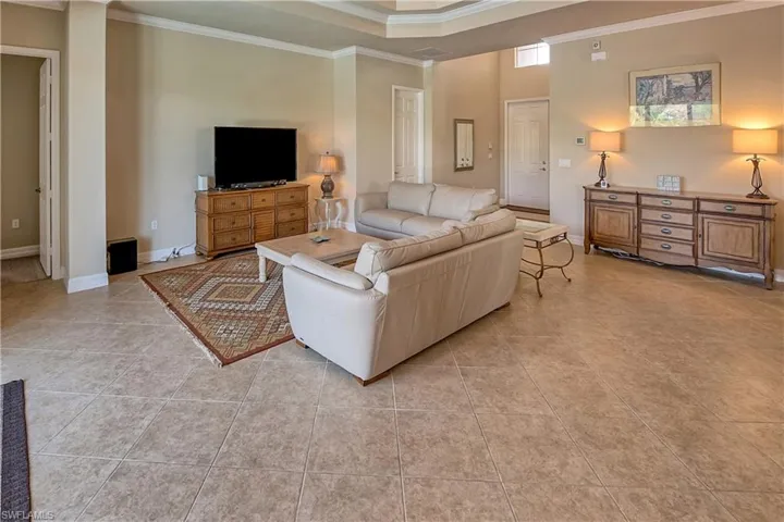 Living room featuring tile patterned flooring and crown molding