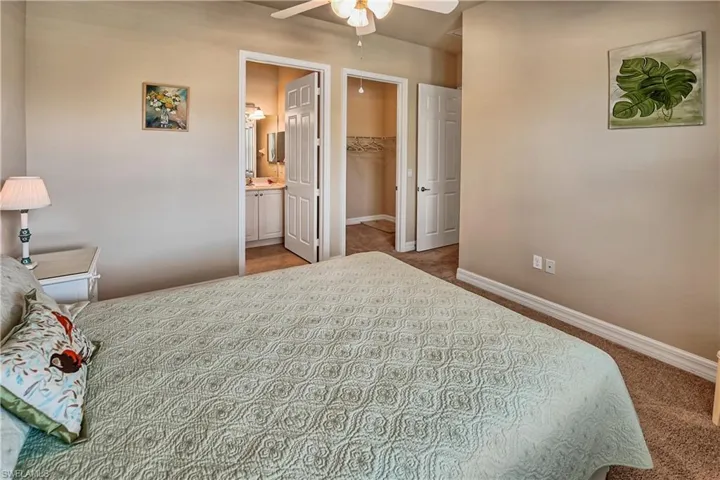 Bedroom featuring carpet flooring, connected bathroom, ceiling fan, a walk in closet, and a closet