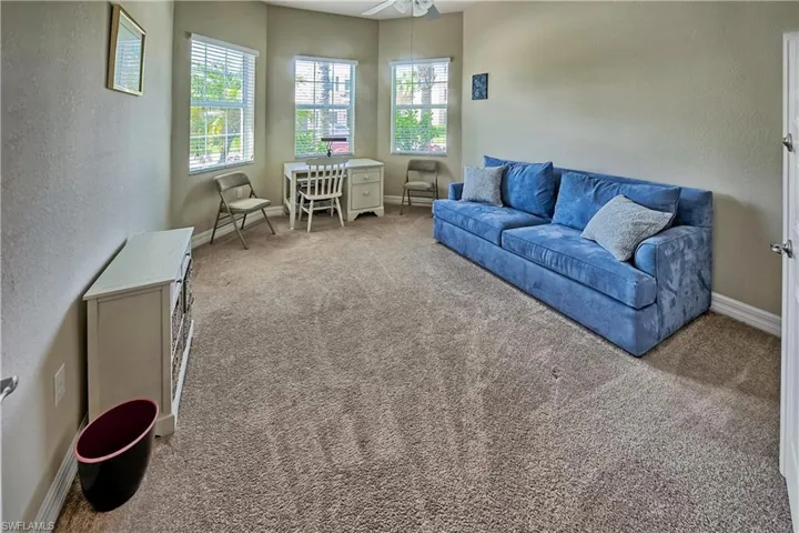 Carpeted living room featuring ceiling fan