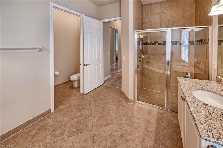 Bathroom with vanity, tile patterned floors, and an enclosed shower