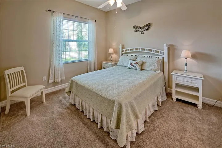 Carpeted bedroom featuring ceiling fan