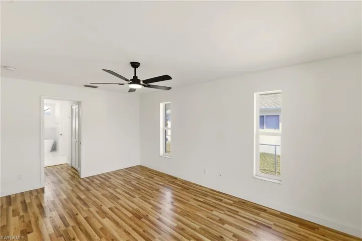 Spare room with light wood finished floors and a ceiling fan