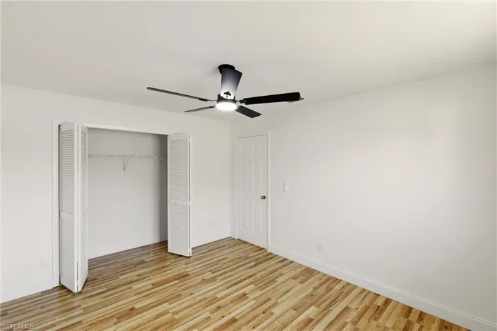 Unfurnished bedroom featuring light wood-type flooring, ceiling fan, and a closet