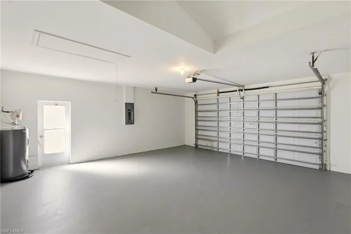 Garage featuring electric water heater and electric panel