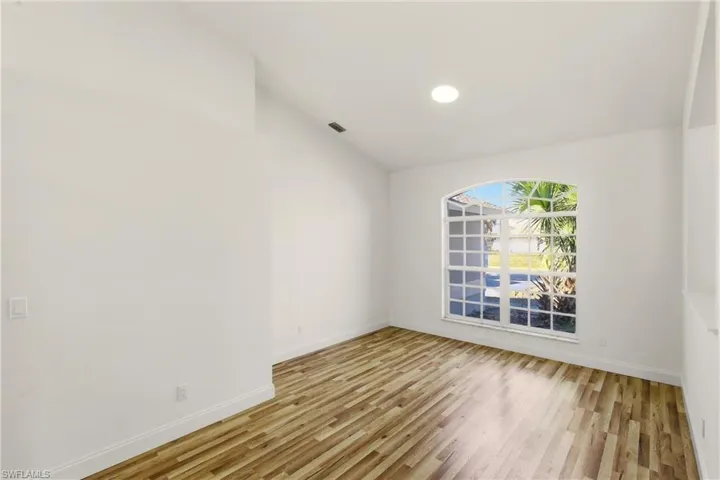Unfurnished room with light wood-style floors, vaulted ceiling, and recessed lighting