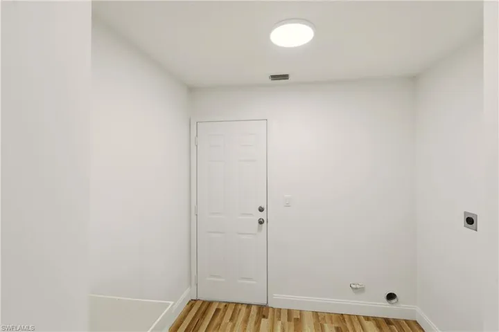 Laundry area featuring light wood-style flooring and hookup for an electric dryer