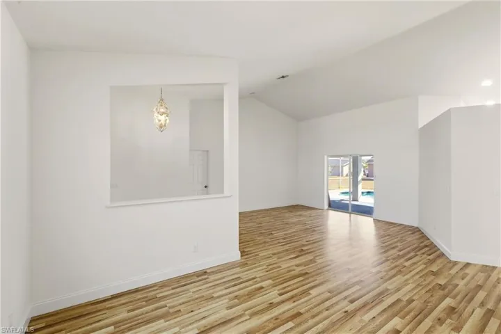 Empty room featuring light wood-style flooring and lofted ceiling