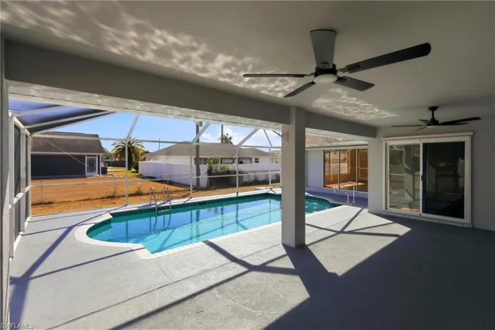 Outdoor pool with a patio, a sunroom, and a lanai