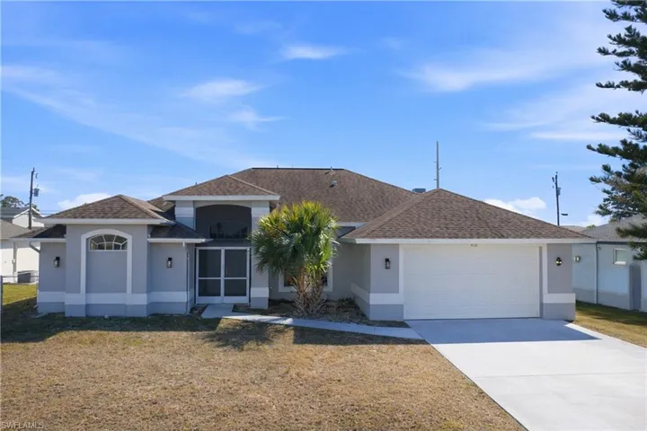 View of front of house with an attached garage, stucco siding, concrete driveway, a front yard, and a shingled roof