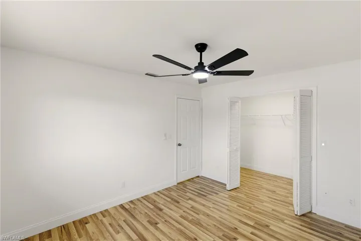 Unfurnished bedroom with light wood-style floors, a ceiling fan, and a closet