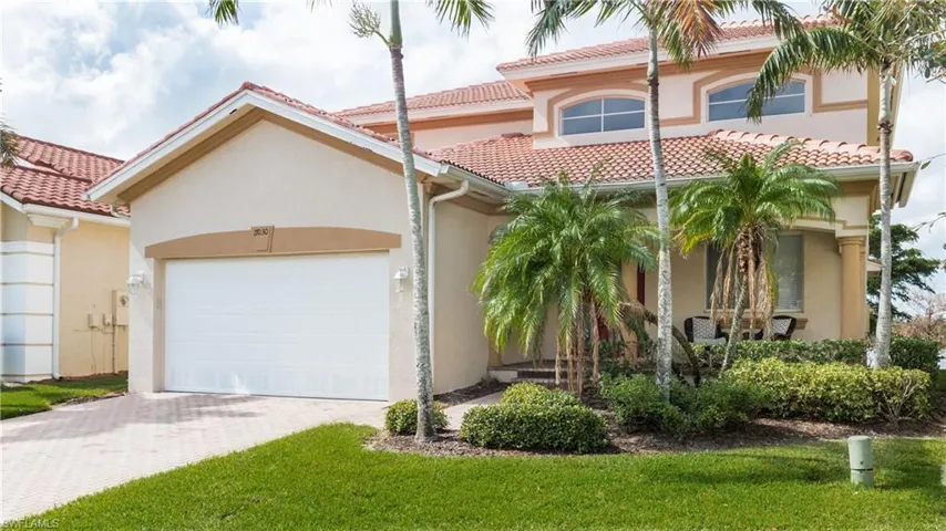 Mediterranean / spanish-style house featuring a garage and a front yard