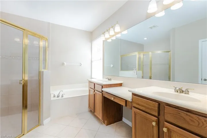 Master Bathroom featuring dual vanity, tile patterned floors, and separate shower and soaking tub