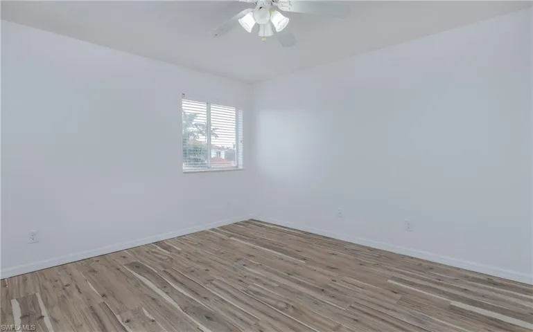 Bedroom #1 upstairs with light LVP flooring and ceiling fan