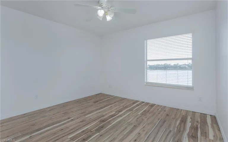 Bedroom #2 upstairs with light LVP flooring and ceiling fan