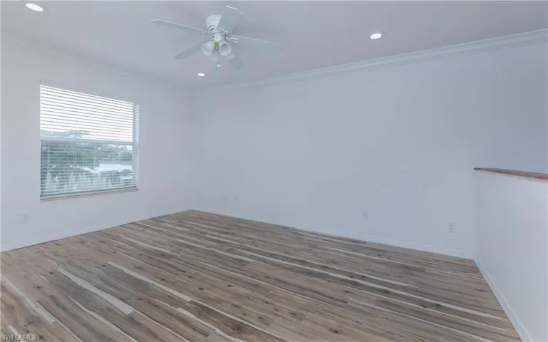 Unfurnished Loft with ceiling fan, light LVP flooring with view of water