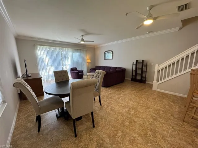 Dining room with ceiling fan and crown molding