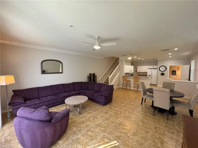 Living room with ceiling fan and ornamental molding