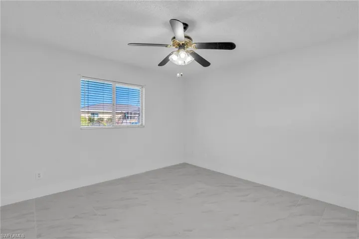Spare room with a textured ceiling and a ceiling fan