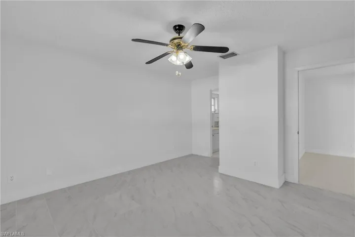 Unfurnished room with a textured ceiling and a ceiling fan