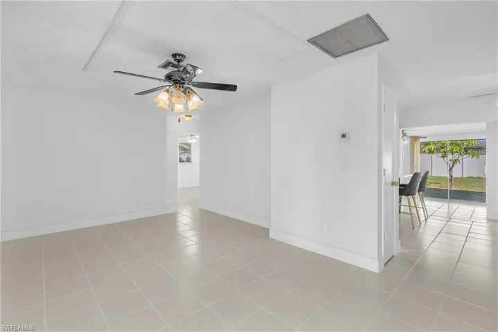 Empty room featuring a ceiling fan and light tile patterned floors