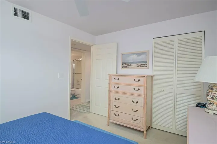 Bedroom with light carpet, a closet, and a ceiling fan