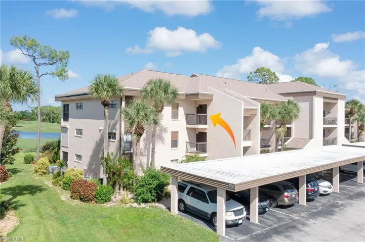 View of building exterior featuring covered parking
