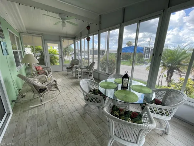 Sunroom featuring a neighborhood view, vaulted ceiling, a wealth of natural light, and ceiling fan