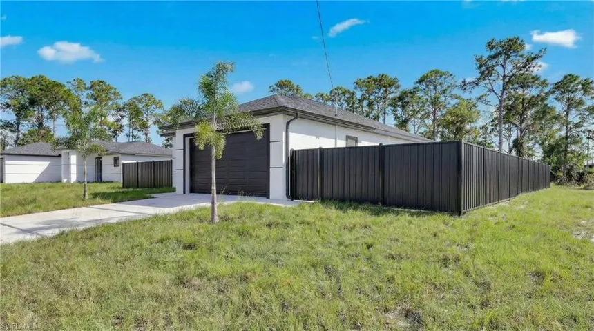 View of side of property featuring stucco siding and concrete driveway