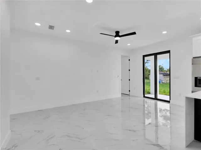 Empty room featuring light marble finish flooring, recessed lighting, and a ceiling fan