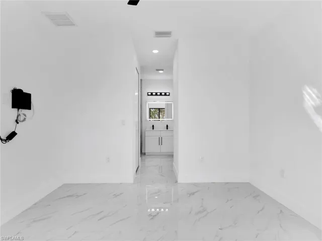Corridor with light marble finish flooring and recessed lighting