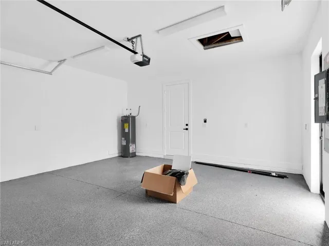 Garage featuring water heater and electric panel