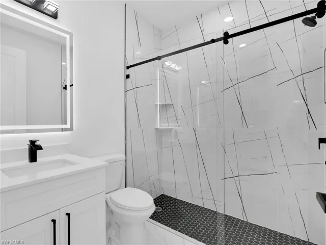 Full bath with a marble finish shower and vanity
